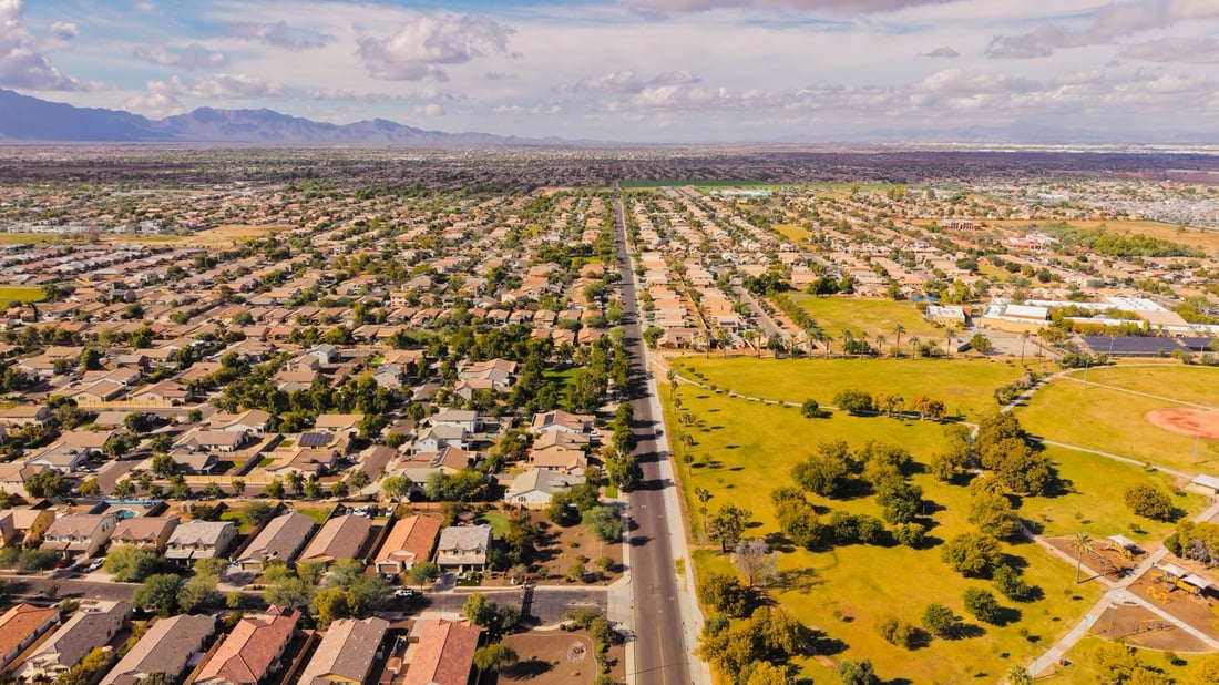 Aerial view of a sprawling suburban neighborhood in Arizona with mountains in the distance