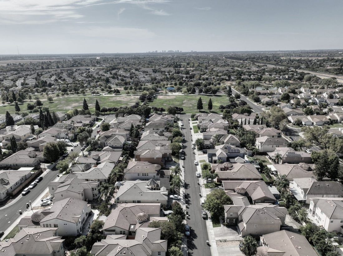 Aerial view of a Sacramento-area suburb with the downtown skyline in the distance