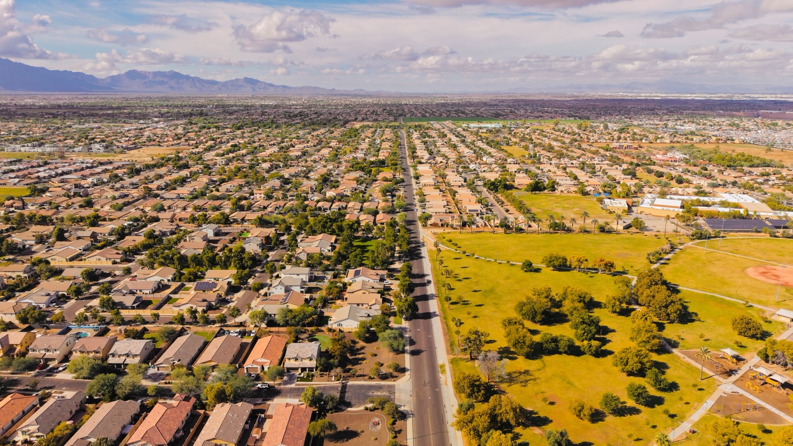 Aerial view of a sprawling suburban neighborhood in Arizona with mountains in the distance