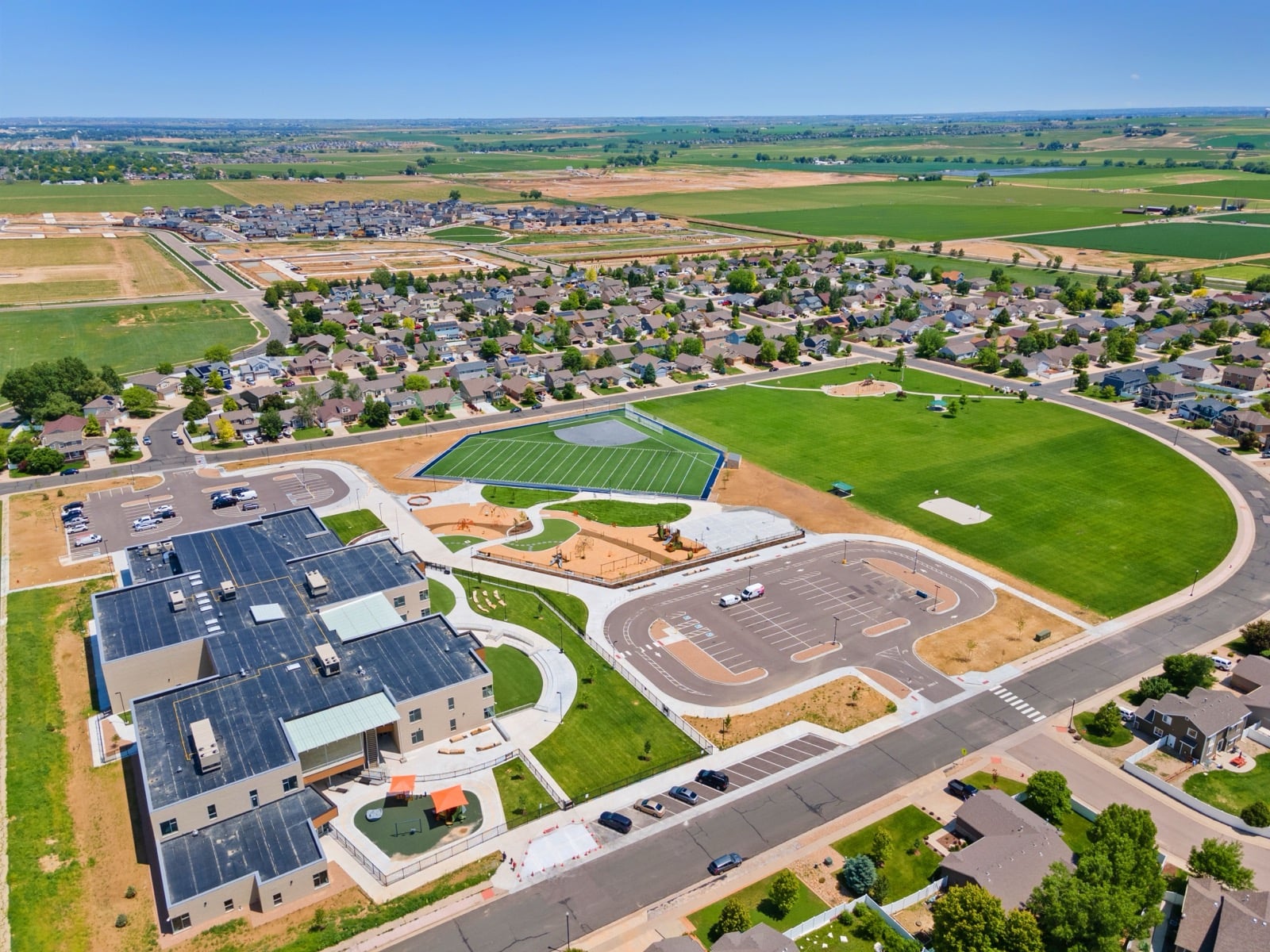 Aerial view of a new suburban development with parks and community amenities in Johnstown, Colorado