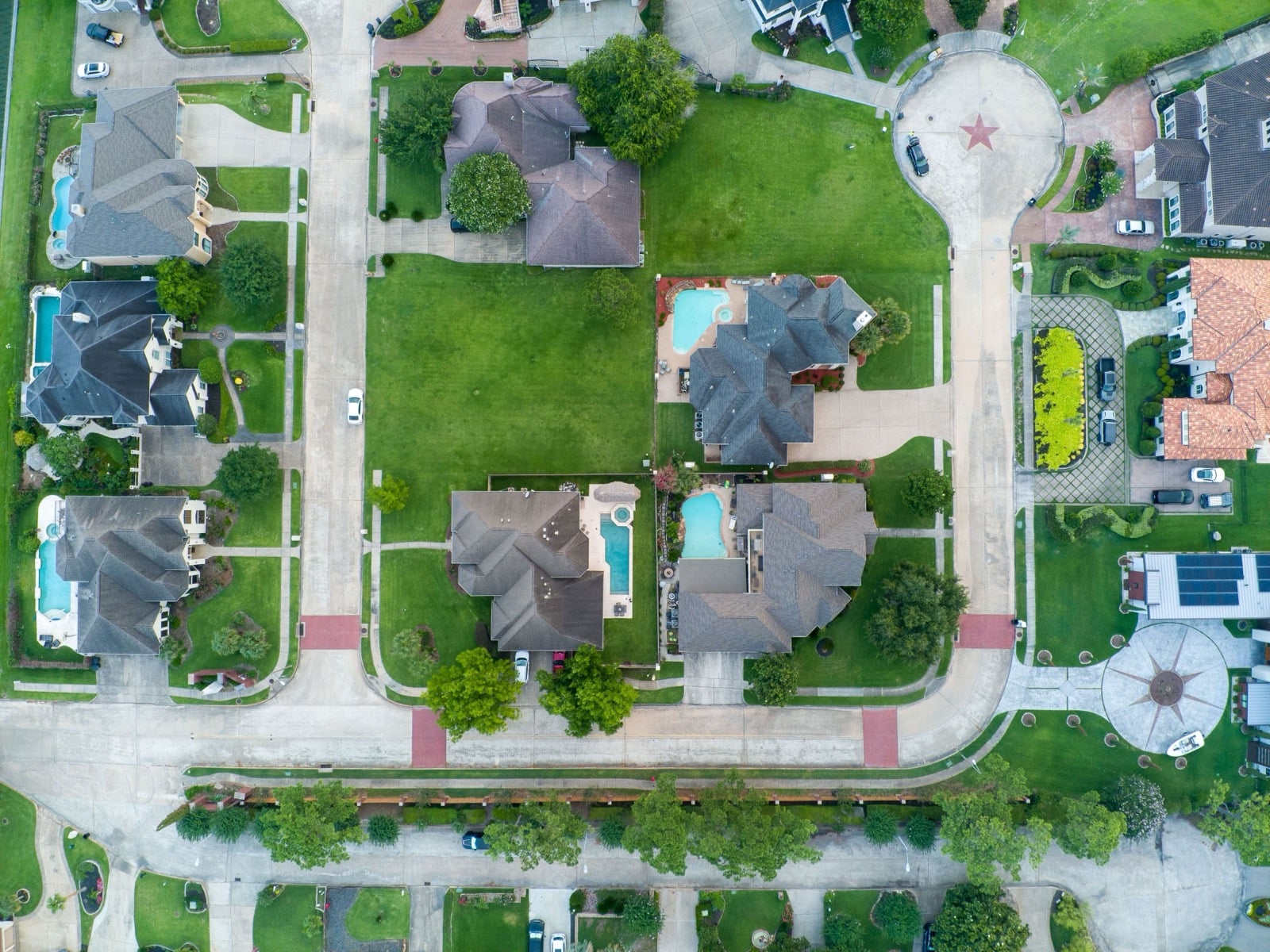 Top-down aerial view of single-family homes with pools in a Houston, Texas neighborhood