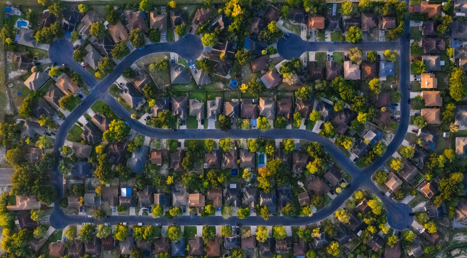 Aerial view of a Texas suburban neighborhood of single-family homes at dusk