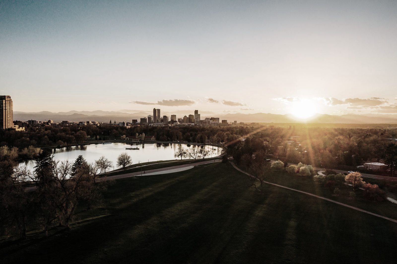 Denver skyline at sunset with the Rocky Mountains behind